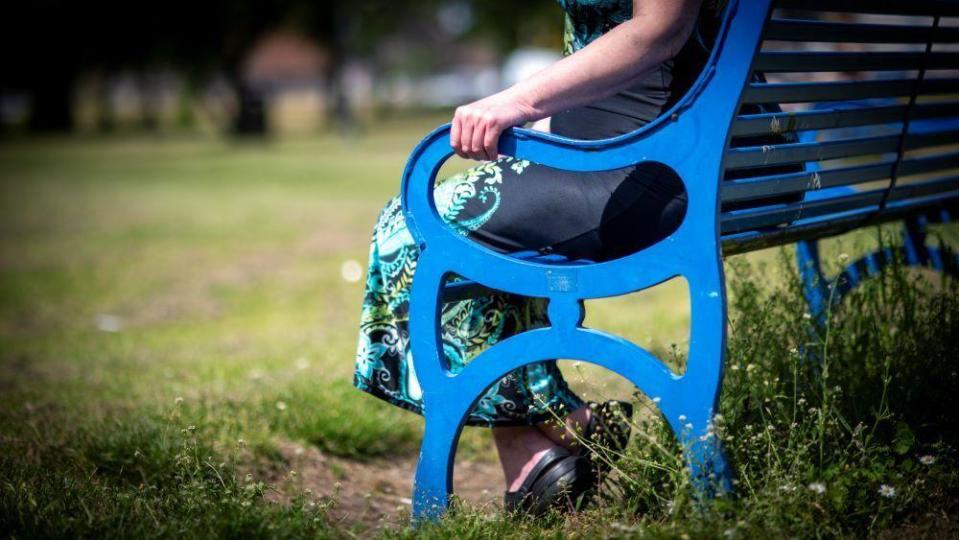 Anonymous shot of Heidi's hand on a park bench