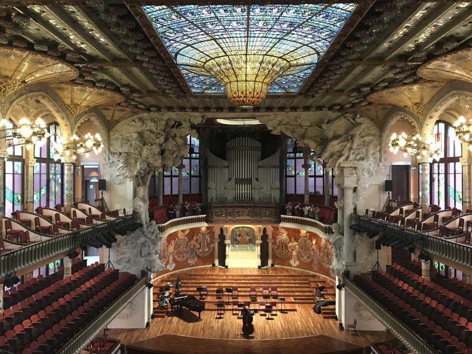 This Oct. 14, 2019 photo shows the inside of Palau de la Música Catalana, built by famed architect Lluís Domènech I Montaner, in Barcelona, Spain. A required tour of the music hall’s crescendo of colorful stained glass and mosaics is pricey but worth it, and you may even catch musicians practicing. (Courtney Bonnell via AP)