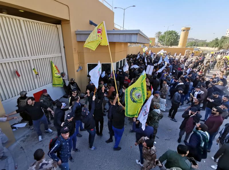 Manifestantes y milicianos se reúnen para condenar los ataques aéreos a las bases pertenecientes a Hashd al-Shaabi (fuerzas paramilitares), frente a la puerta principal de la embajada de Estados Unidos en Bagdad, Irak, el 31 de diciembre de 2019