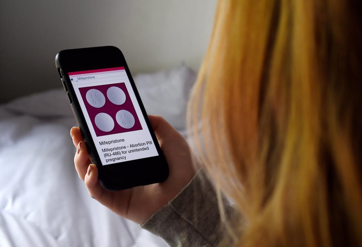 <span class="caption">The mifepristone pill is one option for medication abortion that can be purchased online and used at home.</span> <span class="attribution"><a class="link " href="https://www.gettyimages.com/detail/news-photo/in-this-photo-illustration-a-person-looks-at-an-abortion-news-photo/1212435851" rel="nofollow noopener" target="_blank" data-ylk="slk:Olivier Douliery/AFP via Getty Images;elm:context_link;itc:0;sec:content-canvas">Olivier Douliery/AFP via Getty Images</a></span>