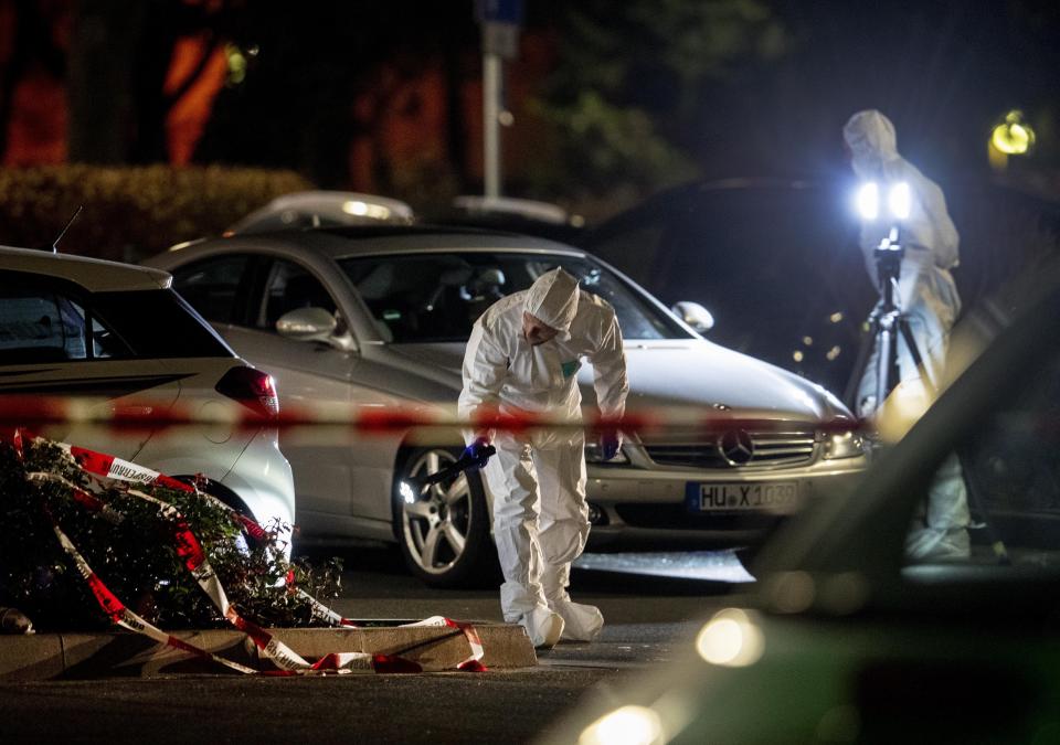 Forensics investigate at the scene after a shooting in central Hanau, Germany Thursday, Feb. 20, 2020. Eight people were killed in shootings in the German city of Hanau on Wednesday evening, authorities said. (AP Photo/Michael Probst)