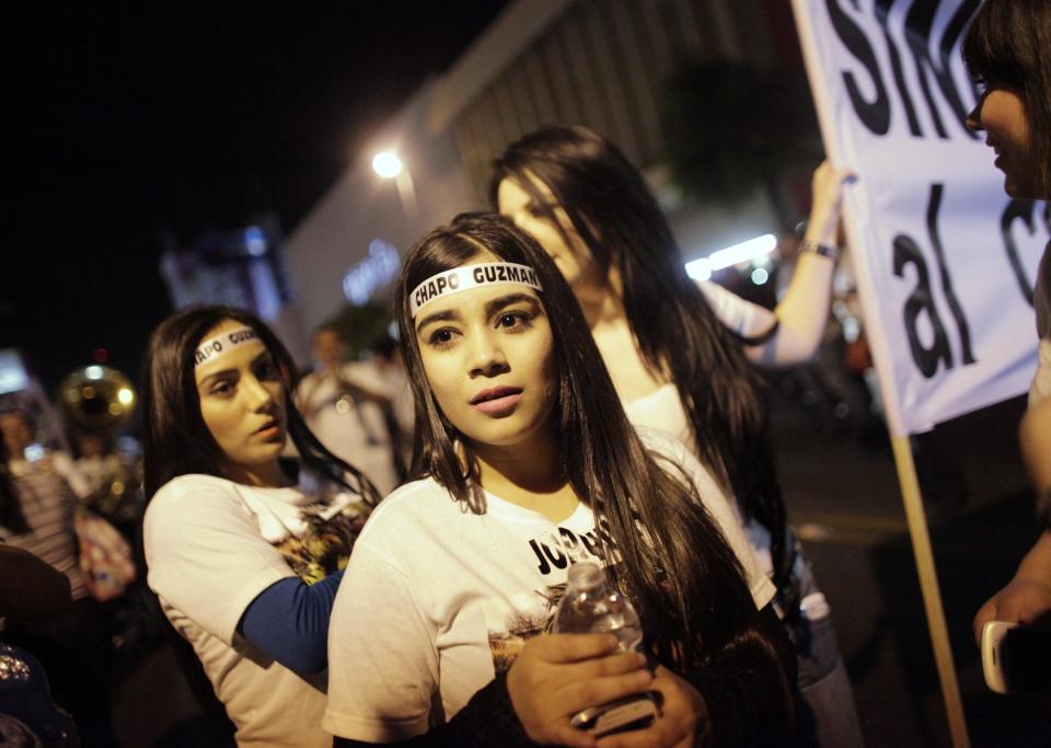 Young women wear headbands featuring the name of Chapo Guzman during a march in Culiacan