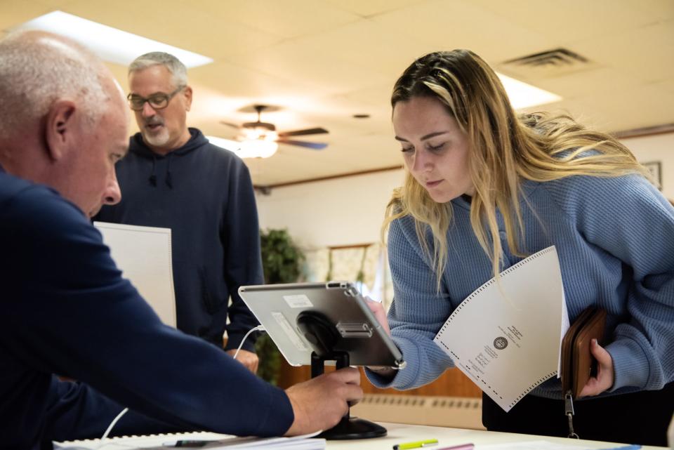 Lauren Day signs in to vote in the midterm election at a polling place inside the Plumseadville Firehouse in Plumstead Township on Tuesday, November 8, 2022.