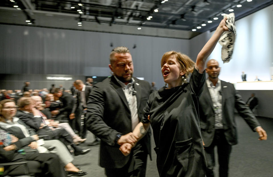 Climate activists are taken out of the venue of the annual shareholders' meeting of the Volkswagen AG in Berlin, Germany, Wednesday, May 10, 2023. (Britta Pedersen/dpa via AP)