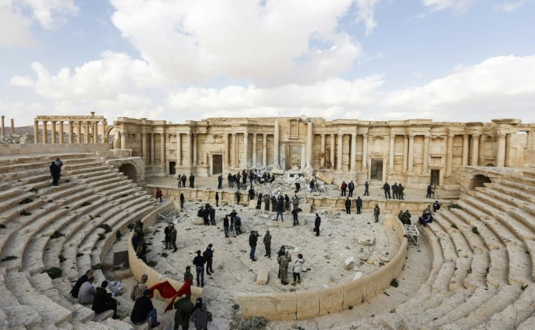 Journalists inspect the damaged Roman amphitheatre in the ancient Syrian city of Palmyra on March 4, 2017