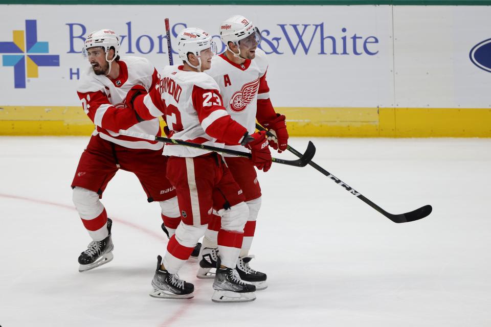 (From left) Red Wings center Dylan Larkin and left wing Lucas Raymond celebrate a goal by left wing David Perron during the second period on Saturday, Dec. 10, 2022, in Dallas.