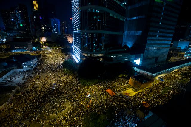 Thousands of protesters attend a rally outside the government headquarters in Hong Kong as riot police stand guard September 27, 2014. 