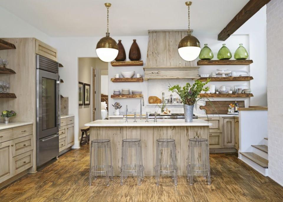 an all wood kitchen with clear barstools and white countertops