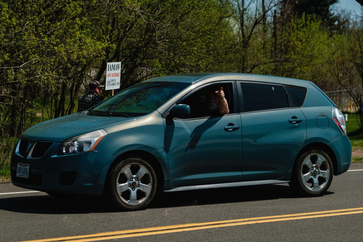 A passing motorist gestures towards picketing members of the International Association of Machinists (IAMAW) currently employed by Gradall Industries, Inc., in New Philadelphia, Monday, April 15.