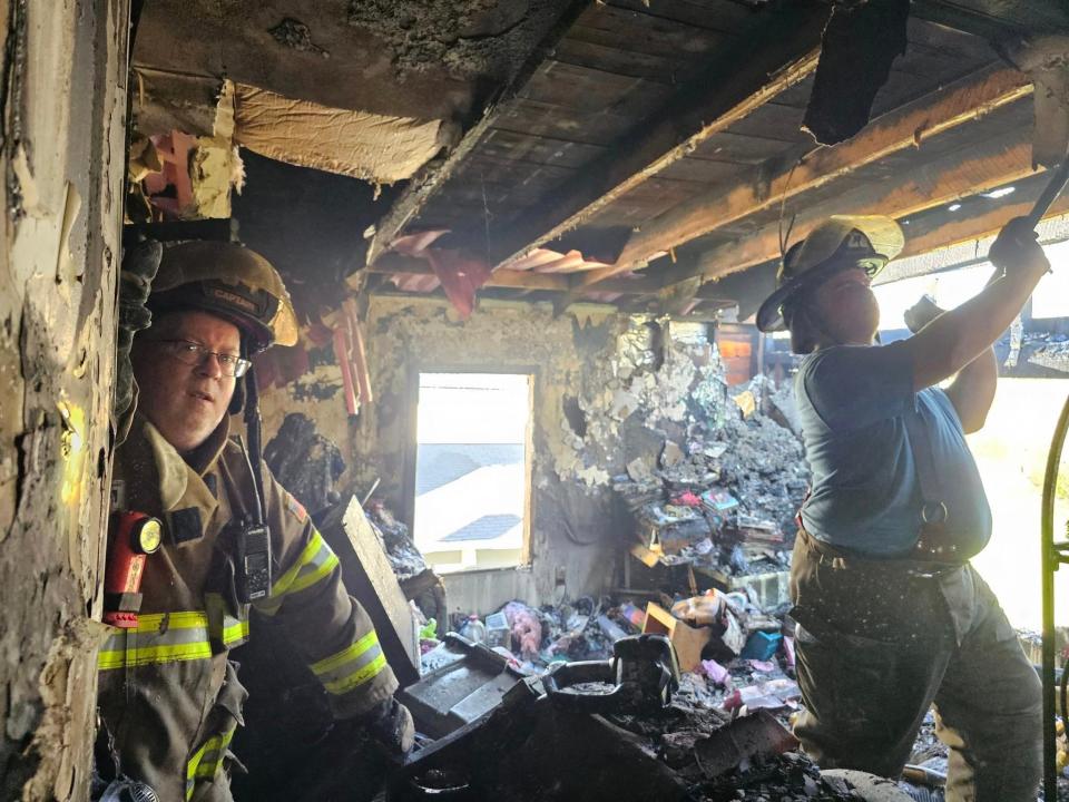 Firefighters work inside a home at 311 S. Market St. in Minerva that burned Thursday afternoon.