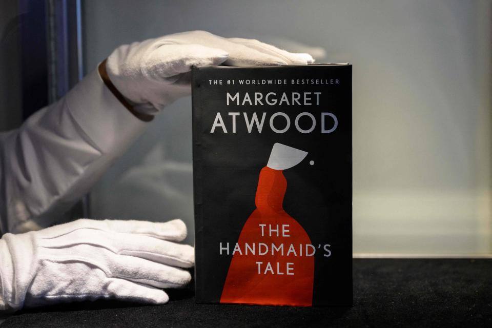 An art handler holds Margaret Atwood's Unburnable Book, a fireproof edition of her prescient and often banned book "The Handmaid's Tale" at Sotheby's in New York City on June 3, 2022.