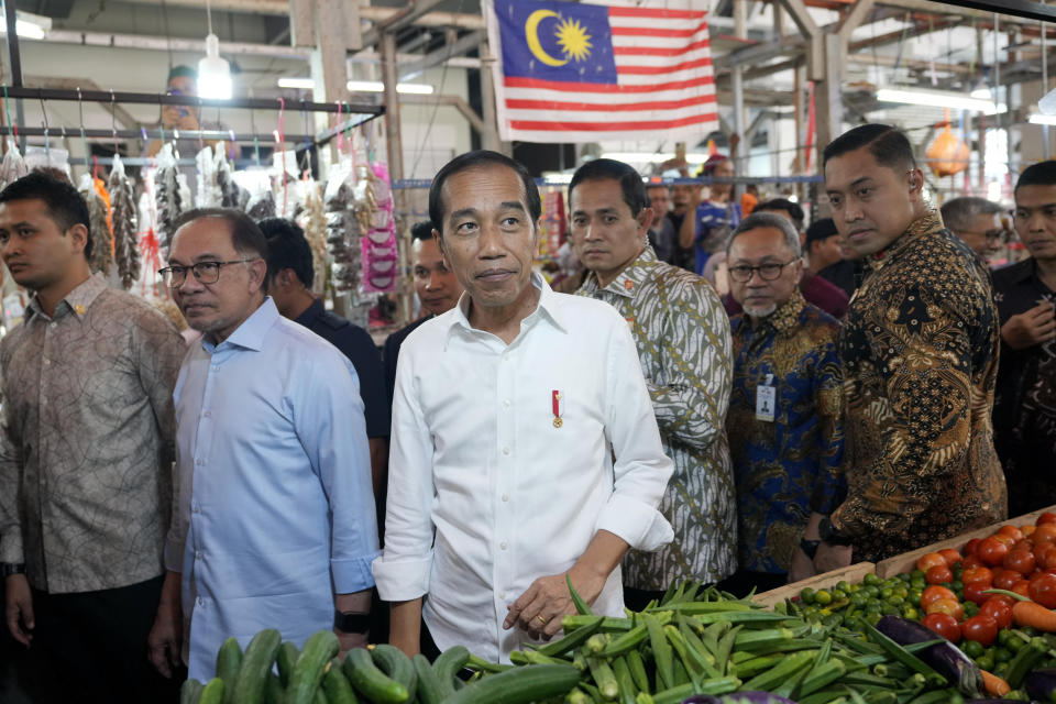 Indonesian President Joko Widodo, center, walks with Malaysian Prime Minister Anwar Ibrahim, second left, as they visit a local wet market in Kuala Lumpur, Malaysia, Thursday, June 8, 2023. (AP Photo/Vincent Thian)