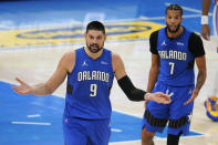 Orlando Magic center Nikola Vucevic (9) and guard Michael Carter-Williams (7) react to a call during the second half of the team's NBA basketball game against the Oklahoma City Thunder, Tuesday, Dec. 29, 2020, in Oklahoma City. (AP Photo/Sue Ogrocki)