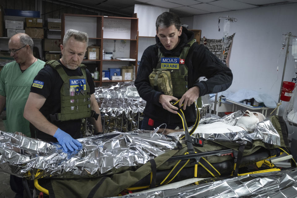 Paramedics prepare a wounded Ukrainian soldier for evacuation at a medical stabilisation point near Bakhmut, Donetsk region, Ukraine, Friday, May 24, 2024. (Iryna Rybakova via AP)