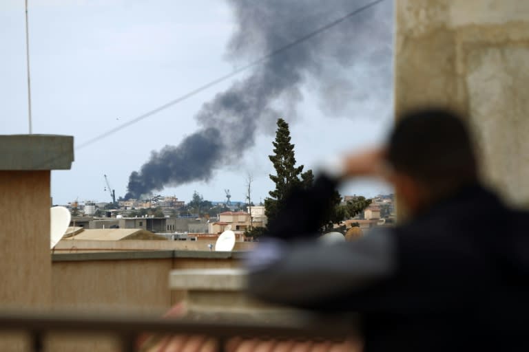 Smoke rises from the port of the eastern Libyan city of Benghazi on February 14, 2015 during clashes between forces loyal to the internationally recognised government and Islamist militias