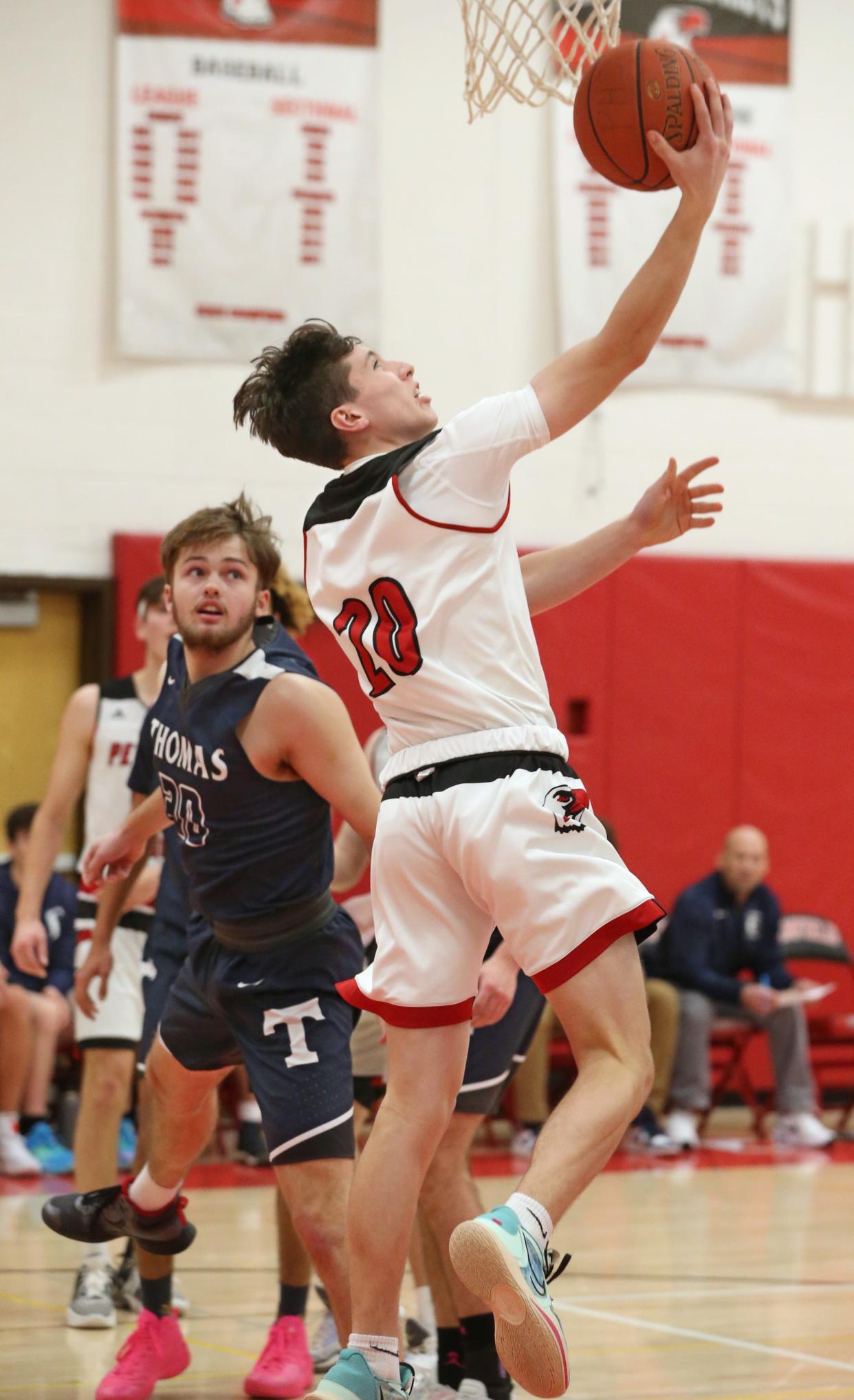 Penfield's Trevor Hofer (20), puts up a reverse layup past Thomas' Shane Talbot during their Section V boys basketball matchup Tuesday, Jan. 3, 2023 at Penfield High School.