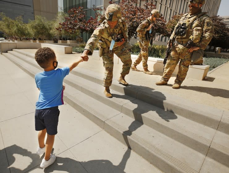 LOS ANGELES, CA - JUNE 04: 4-year-old Braydon Deauce White fist pumps a National Guardsmen at LAPD Headquarters Thursday morning as National Guardsmen remain on patrol surrounding the police headquarters with only a few protestors in sight. Braydon's Mother KimiRochelle Porter, said, "He wants to be a policeman so we brought him here to see how they keep us safe." Central on Thursday, June 4, 2020 in Los Angeles, CA. (Al Seib / Los Angeles Times)