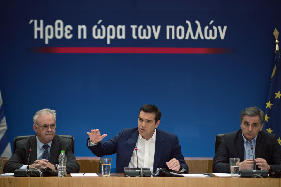 Greek Prime Minister Alexis Tsipras, center, announces bailout relief measures next to the Greek Financial Minister Euklid Tsakalotos, right, and the Deputy Prime Minister Yannis Dragasakis, during a press conference, in Athens, on Tuesday, May 7, 2019. Greece's left-wing prime minister has promised crisis-weary voters a series of tax-relief measures ahead of elections, after outperforming budget targets set by bailout creditors. (AP Photo/Petros Giannakouris)