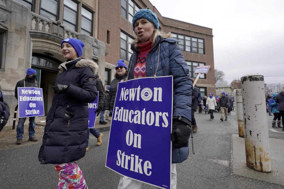 Striking Newton teachers and supporters carry placards while marching, Tuesday, Jan. 30, 2024, outside the Newton Education Center, in Newton, Mass. Contract negotiations between the Newton Teachers Association and the city's School Committee continued Tuesday. (AP Photo/Steven Senne)