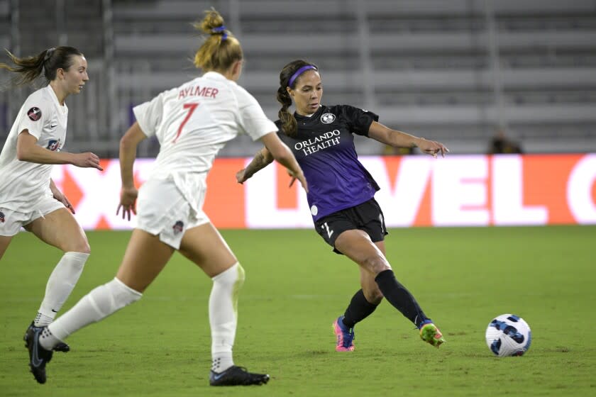 Orlando Pride forward Sydney Leroux passes a ball in front of Washington Spirit's Dorian Bailey, left, and Taylor Aylmer