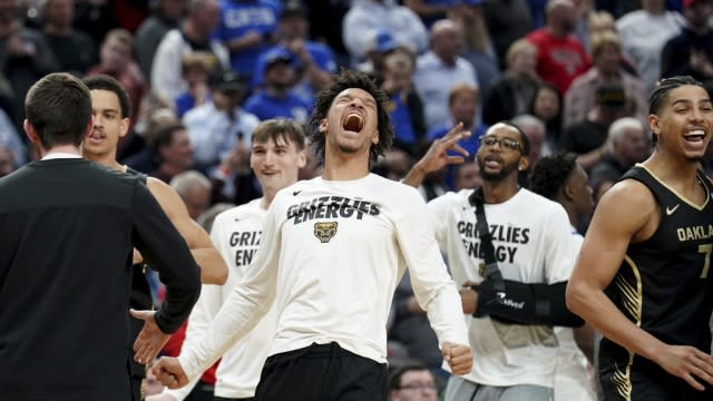 Oakland players celebrate after defeating Kentucky in a college basketball game.