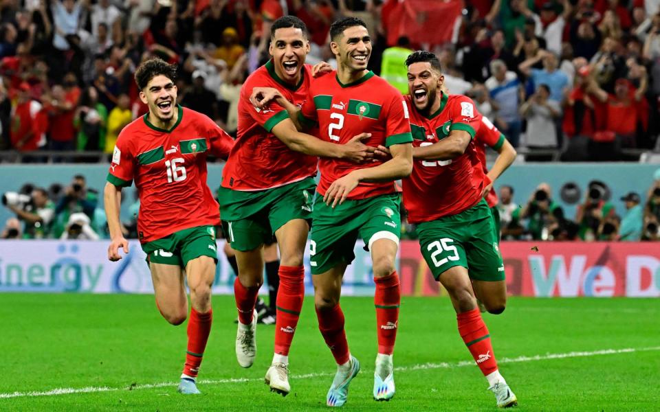 Achraf Hakimi (C) celebrates with teammates after converting the last penalty during the penalty shoot-out to win the Qatar 2022 World Cup round of 16 football match between Morocco and Spain at the Education City Stadium - World Cup 2022 quarter-finals: When are they, which teams are left and knockout fixtures - Javier Soriano/Getty Images