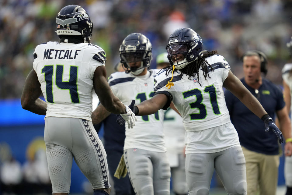 Seattle Seahawks running back DeeJay Dallas (31) celebrates with wide receiver DK Metcalf (14) after Metcalf scored a touchdown during the first half of an NFL football game against the Los Angeles Rams Sunday, Nov. 19, 2023, in Inglewood, Calif. (AP Photo/Ashley Landis)