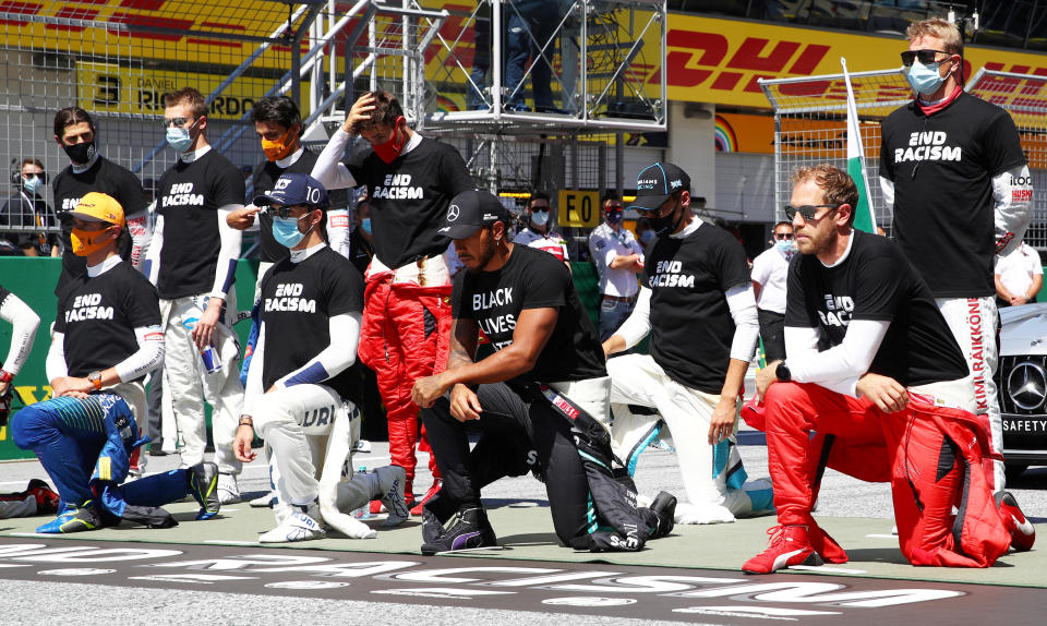 Formula One F1 - Austrian Grand Prix drivers, including Mercedes' Lewis Hamilton, Ferrari's Sebastian Vettel and others, kneel on the grid wearing anti-racism T-shirts before the race on July 5, 2020.  / Credit: POOL / REUTERS