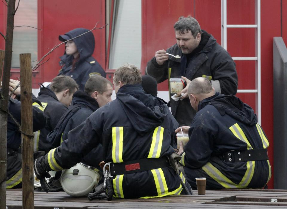 Firefighters rest and eat near a collapsed supermarket in capital Riga