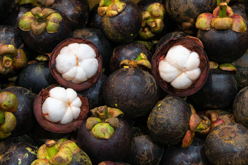 Close-up shot of organic purple mangosteens (Garcinia mangostana), Bangkok, Thailand. Regarding as a queen of fruit, mangosteen is full of many functional compounds including anthocyanin and xanthone that ameliorate many health benefits.