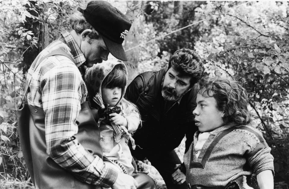 American actor and director Ron Howard, actor Dawn Downing, American director and producer George Lucas, and British actor Warwick Davis discuss a scene on the set of the fantasy feature film, 'Willow,' 1988. (Photo by Lucasfilm/MGM/Courtesy of Getty Images)