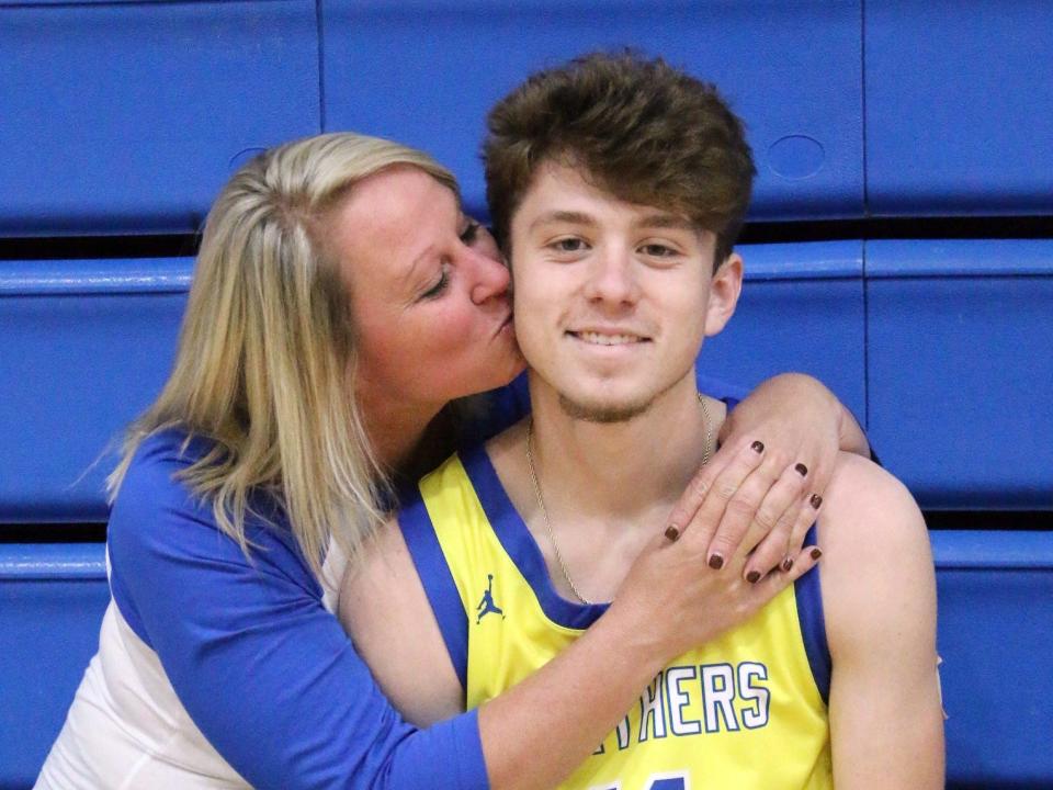 Maysville High School senior Cole Roberts gets a kiss on the cheek from his mother, Tomi, prior to a game. Roberts had surgery to remove a rare form of melanoma and has returned to help lead the Panthers' boys basketball team to a 13-0 record.