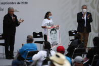 Mexico's President Andres Manuel Lopez Obrador, left, and Deputy Interior Secretary Alejandro Encinas, right, applaud for Maria Martinez, mother of Miguel Angel Hernandez Martinez, as she is introduced as a representative of the family members of 43 missing students from the Rural Normal School of Ayotzinapa, during an event to update the ongoing investigations on the sixth anniversary of the students’ disappearance, at the National Palace in Mexico City, Saturday, Sept. 26, 2020. (AP Photo/Rebecca Blackwell)