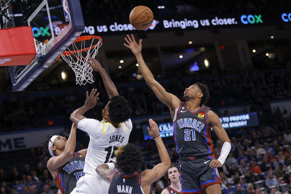 Oklahoma City Thunder guard Aaron Wiggins (21) grabs a rebound near, from left to right, Thunder forward Ousmane Dieng, Utah Jazz center Damian Jones and Thunder guard Tre Mann during the second half of an NBA basketball game Friday, March, 3, 2023, in Oklahoma City. (AP Photo/Nate Billings)