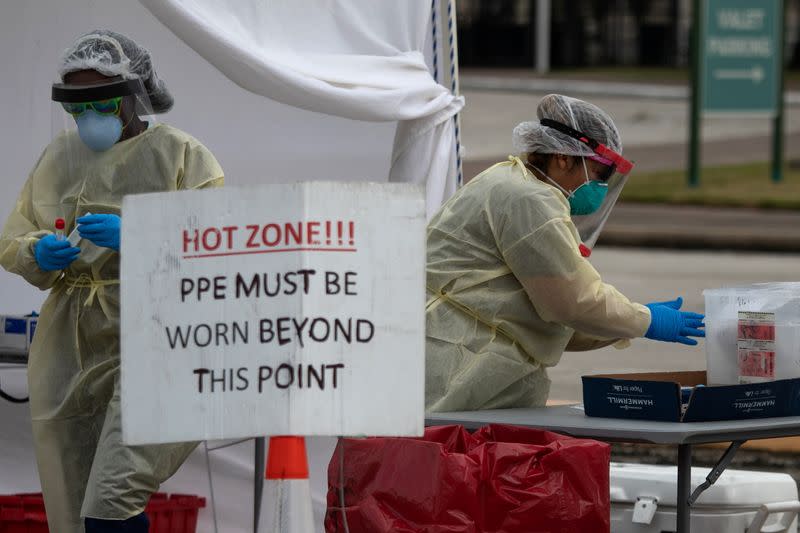 Healthcare workers prepare specimen collection tubes at a coronavirus disease (COVID-19) drive-thru testing location in Houston