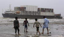 Youth play near the stranded Heng Tong 77 cargo ship at Sea View Beach near the southern port city of Karachi, Pakistan, Monday, July 26, 2021. Pakistani authorities said they are working on plans to refloat the cargo ship that ran aground last week amid bad weather en route to Istanbul from China. (AP Photo/Fareed Khan)