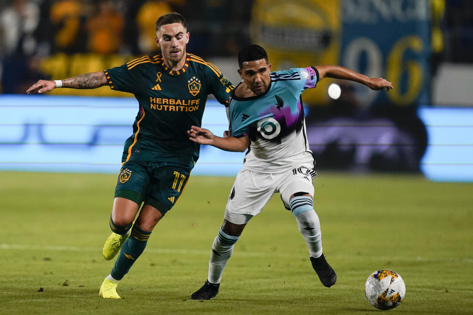 LA Galaxy midfielder Tyler Boyd, left, and Minnesota United midfielder Emanuel Reynoso vie for the ball during the first half of an MLS soccer match Wednesday, Sept. 20, 2023, in Carson, Calif. (AP Photo/Ryan Sun)