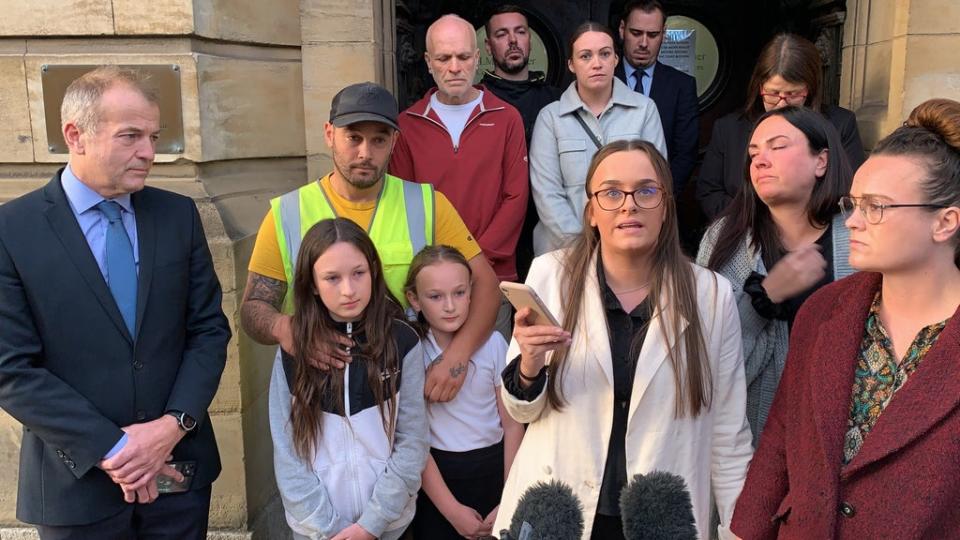 Tia Skelton, centre, the sister of Lewis Skelton, is surrounded by members of their family and solicitor Neil Hudgell, left, as she reads a statement to the media outside Hull Coroner’s Court (Dave Higgens/PA) (PA Wire)