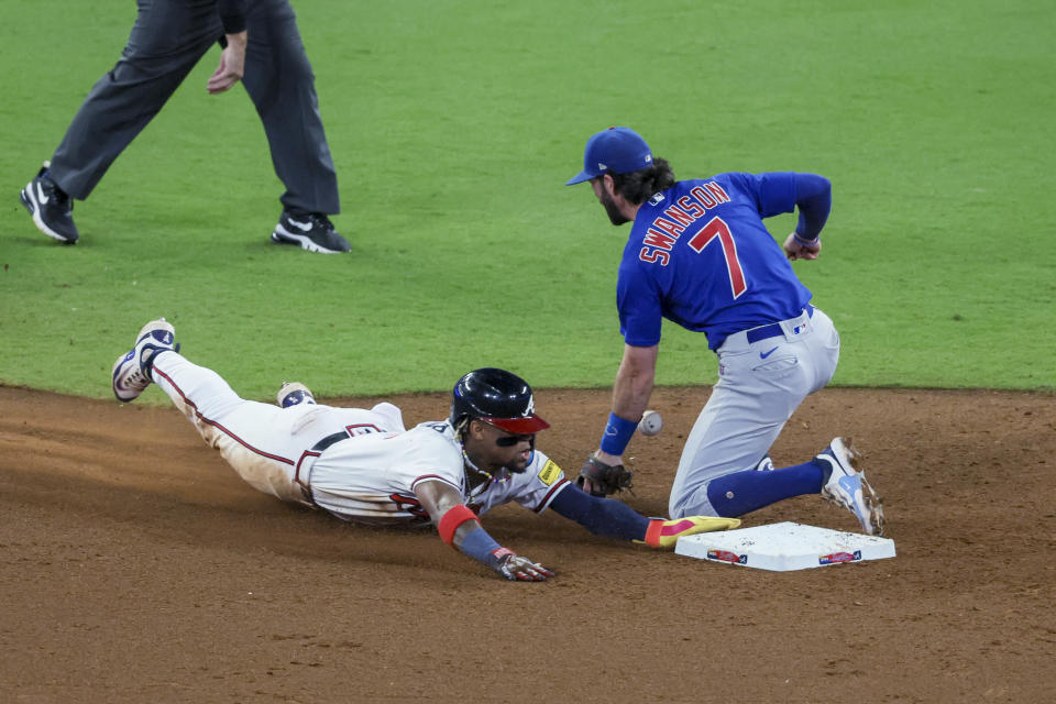 Atlanta Braves' Ronald Acuña Jr. steals second base ahead of the tag by Chicago Cubs shortstop Dansby Swanson (7) during the 10th inning of a baseball game Wednesday, Sept. 27, 2023, in Atlanta. This was Acuña's 70th stolen of the season. (Jason Getz/Atlanta Journal-Constitution via AP)