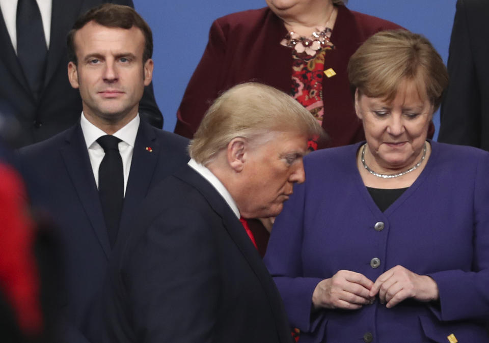 FILE - In this Dec. 4, 2019 file photo U.S. President Donald Trump, center, walks by French President Emmanuel Macron, left, and German Chancellor Angela Merkel, right, prior to a group photo of NATO leaders during a NATO leaders meeting at The Grove hotel and resort in Watford, Hertfordshire, England. Angela Merkel has just about seen it all when it comes to U.S. presidents. Merkel on Thursday makes her first visit to the White House since Joe Biden took office. He is the fourth American president of her nearly 16-year tenure as German chancellor. (AP Photo/Francisco Seco, FIle)