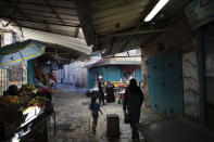 In this Tuesday, Sept. 24, 2019 photo, Israeli Arabs walk at the market in the old city of Acre, northern Israel. Electoral gains made by Arab parties in Israel, and their decision to endorse one of the two deadlocked candidates for prime minister, could give them new influence in parliament. But they also face a dilemma dating back to Israel's founding: How to participate in a system that they say relegates them to second-class citizens and oppresses their Palestinian brethren in Gaza and the occupied West Bank. (AP Photo/Oded Balilty)