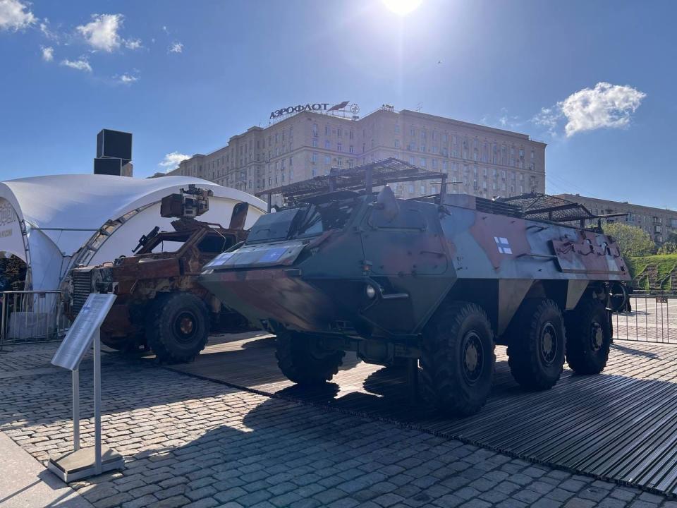 A Finnish Patria Pasi APC sits in front of an information placard.