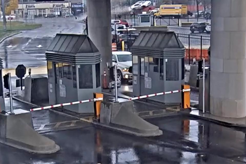 In this image taken from security video, a light colored vehicle, top center, flies over a fence into the Rainbow Bridge customs plaza, Wednesday, Nov. 22, 2023, in Niagara Falls (AP)