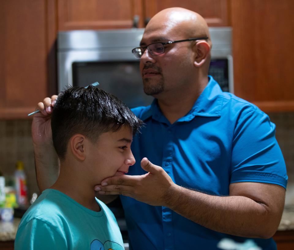 Dereck Marquez combs his son Daniel’s hair June 24 at their Cape Coral home. Daniel was arrested by the Lee County Sheriff’s Office after allegedly making a threat.