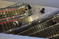 People wearing protective masks to help curb the spread of the coronavirus take usually crowded escalators at a shopping arcade in Tokyo Saturday, Jan. 9, 2021. The Japanese capital confirmed more than 2200 new coronavirus cases on Saturday. Japanese Prime Minister Yoshihide Suga declared a state of emergency last Thursday for Tokyo and three other prefectures to ramp up defenses against the spread of the coronavirus. (AP Photo/Eugene Hoshiko)