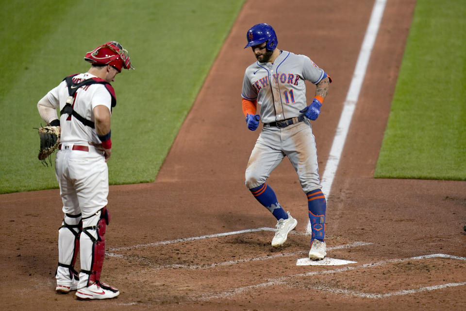 New York Mets' Kevin Pillar (11) arrives home after hitting a two-run home run as St. Louis Cardinals catcher Andrew Knizner watches during the third inning of a baseball game Monday, May 3, 2021, in St. Louis. (AP Photo/Jeff Roberson)