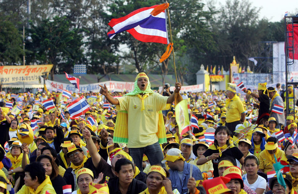 FILE - In this Feb. 4, 2006, file photo, Thai protesters wave flags and cheer during a rally opposing Prime Minister Thaksin Shinawatra at the Royal Plaza in Bangkok, Thailand. Thailand's Yellow Shirts and Red Shirts represent two opposing political factions: respectively, opponents of former Prime Minister Thaksin Shinawatra, and his supporters. The Yellow Shirts derived their identity from the color associated with the late King Bhumibol Adulyadej. (AP Photo/Sakchai Lalit, File)