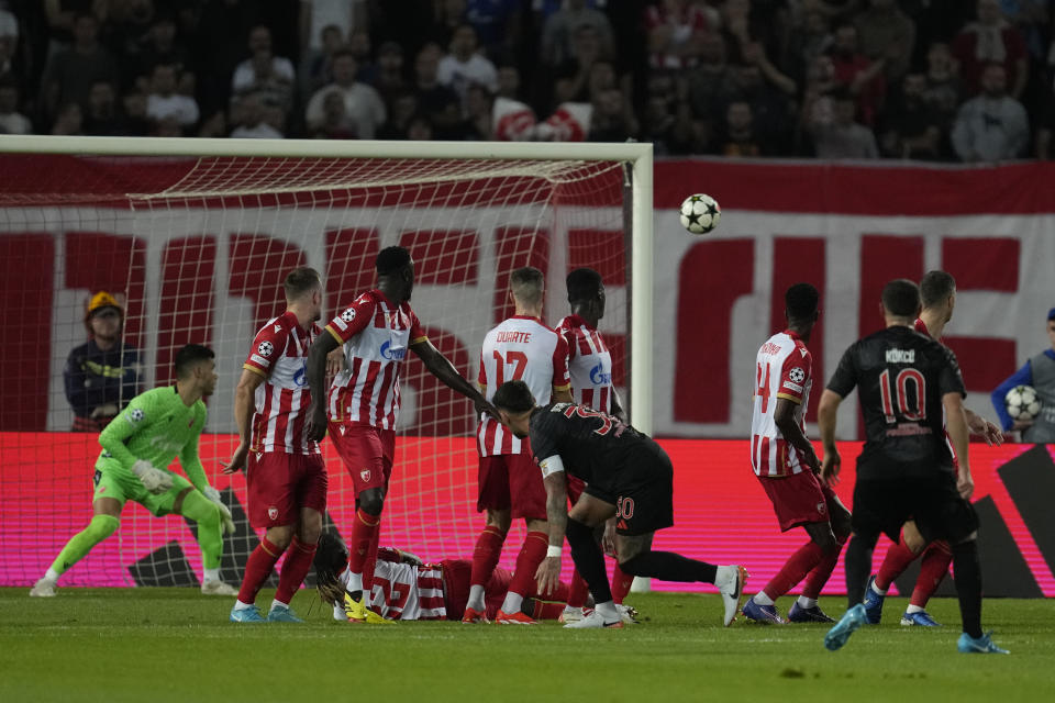 Benfica's Orkun Kokcu, right, scores a free kick, his side's second goal during the Champions League opening phase soccer match between Red Star and SL Benfica, at the Rajko Mitic Stadium in Belgrade, Serbia, Thursday, Sept. 19, 2024. (AP Photo/Darko Vojinovic)