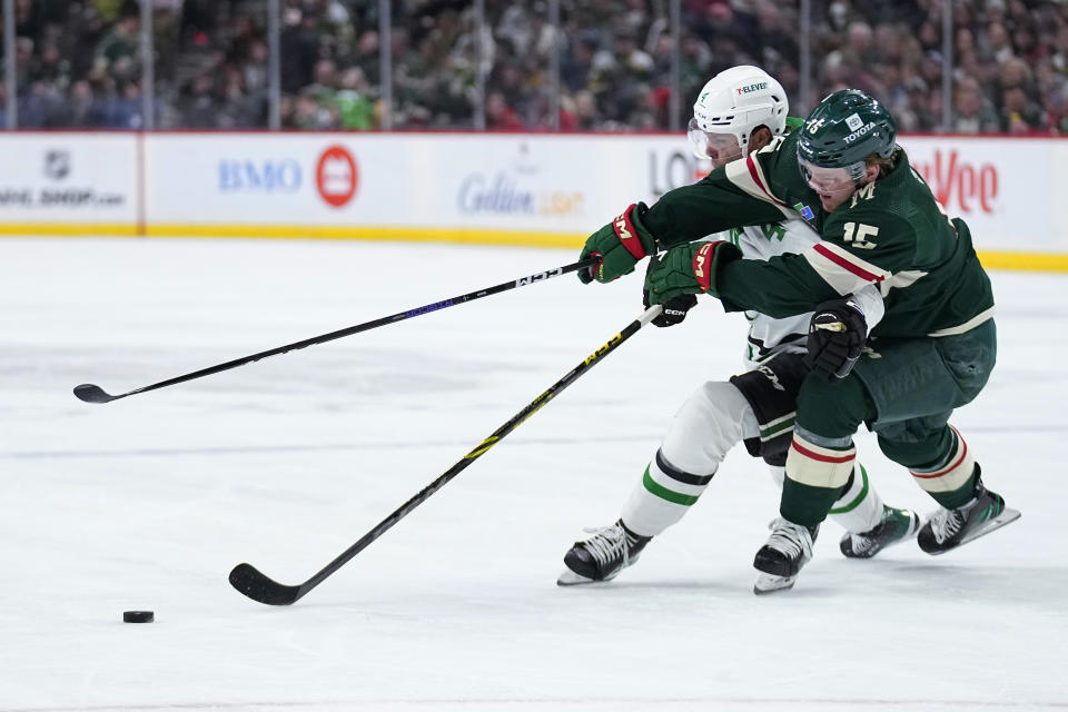 Dallas Stars defenseman Miro Heiskanen, left, and Minnesota Wild center Mason Shaw vie for the puck during the second period of an NHL hockey game Friday, Feb. 17, 2023, in St. Paul, Minn. (AP Photo/Abbie Parr)