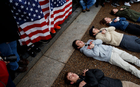 Demonstrators participate in a "lie-in" during a protest in favor of gun control reform in front of the White House - Credit: AP Photo/Evan Vucci
